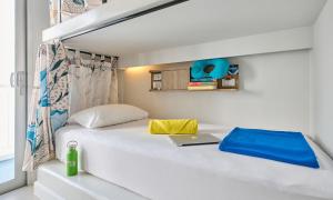 a bedroom with a white bed with a laptop on it at Lub d Phuket Patong - Near Patong Beach & Vibrant Social Vibe in Patong Beach