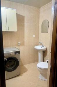 a bathroom with a washing machine and a sink at Batumi sweet home in Batumi +5 photos