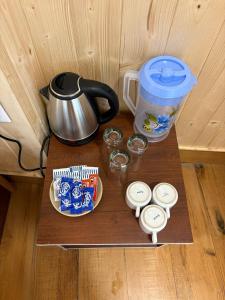 ein Tisch mit einer Teekanne und Schüsseln mit Essen in der Unterkunft HOTEL MANISHA in Gangotri