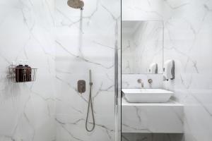 biała łazienka z prysznicem i umywalką w obiekcie Superior Suite by Acropolis Cozy Suites w Atenach