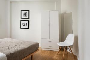 sypialnia z łóżkiem i białym krzesłem w obiekcie Superior Suite by Acropolis Cozy Suites w Atenach