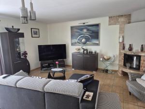 un soggiorno con un divano e una TV di Oaza spokoju a Lednogóra