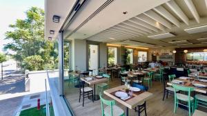 a restaurant with wooden tables and chairs and a large window at Opera Suite Hotel Pesaro in Pesaro