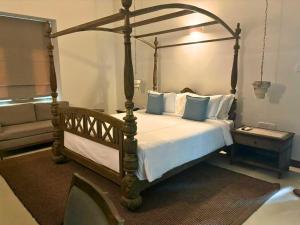 a bedroom with a canopy bed and a couch at Avenue 38 in Kandy