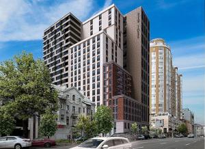キーウにあるPetrovdom Apartments 17-183B in RC New York Concept House, 74 Antonovycha Streetの前に車が駐車されている大きな建物