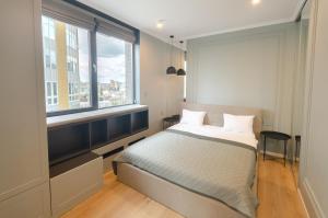 キーウにあるPetrovdom Apartments 17-183B in RC New York Concept House, 74 Antonovycha Streetのベッドと大きな窓のある寝室
