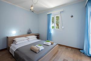 una camera da letto con un grande letto con tende blu di Private Corfu Villa 3 Bedrooms Villa Aziza Great Pool And Outdoor Area a Vouniatádes Altre 16 foto