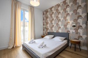 a bedroom with a bed and a large window at Deux pièces abba in Cap d'Ail