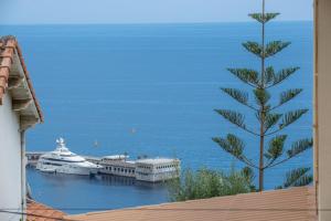 a view of a boat in a harbor with a tree at Deux pièces abba in Cap d'Ail