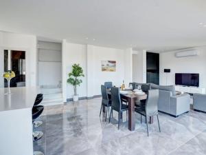 ein Esszimmer und ein Wohnzimmer mit Tisch und Stühlen in der Unterkunft Villa Manta Chrysos - Brand New Luxury 3 Bedroom Protaras Villa in Protaras