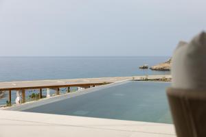 a swimming pool with the ocean in the background at Cavo Marelia in Amoopi