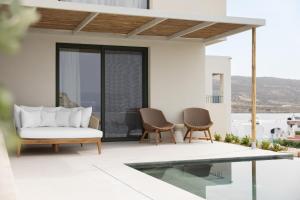 a living room with a couch and chairs on a patio at Cavo Marelia in Amoopi