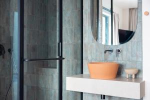 a bathroom with a sink and a shower with a mirror at Cavo Marelia in Amoopi