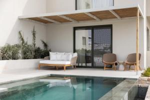a patio with a pool and a couch and chairs at Cavo Marelia in Amoopi
