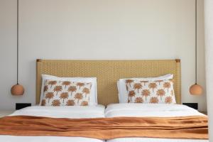 a bed with a large headboard and pillows on it at Cavo Marelia in Amoopi