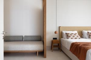a bedroom with a bed and a bench next to it at Cavo Marelia in Amoopi