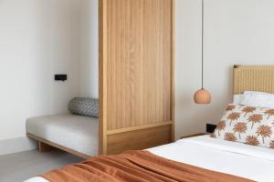 a small bedroom with a bed and a chair at Cavo Marelia in Amoopi