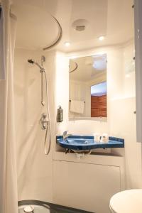 een badkamer met een douche en een blauw bad bij Hotel Castillan in La Grave