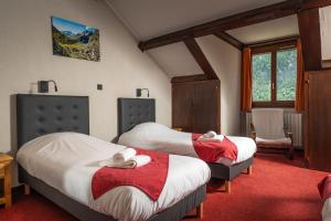 een slaapkamer met 2 bedden en een rode loper bij Hotel Castillan in La Grave