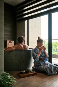 mężczyzna siedzący na podłodze przed łazienką w obiekcie Kobi Onsen Resort Hue, Affiliated by Melia w mieście Hue