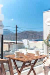 un tavolo in legno con 2 tazze sul balcone di Elysian Studios Karpathos a Karpathos