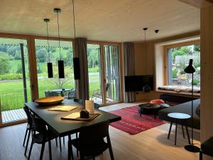 un soggiorno con tavolo, sedie e divano di Bio Design Appartements DAS GRAUE SCHAF - Kärnten Card im Sommer inklusive a Bad Kleinkirchheim