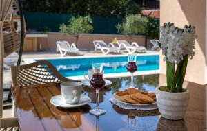 a table with glasses of wine and a plate of cookies at Beautiful Home In Pinezici With Kitchen in Pinezici
