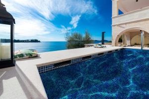 a swimming pool in a house with a view of the ocean at Dazzling Lozica Villa 5 Bedrooms Villa Pasija Steam Room & Private Plateau Beach in Dubrovnik