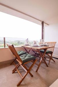 a table and chairs in a room with a large window at Avalón I By Silastur in Villaviciosa