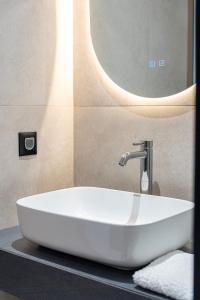 un lavandino bianco in un bagno con uno specchio di Elysian Studios Karpathos a Karpathos