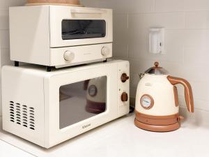 a microwave with a toaster oven on top of it at 3-Min Walk from Achasan Station, 2-Bedroom Bali Mood Stay with Hinoki Aroma in Seoul