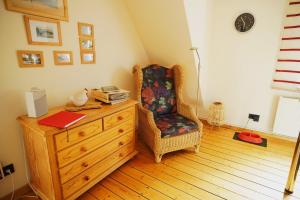 a room with a chair and a dresser with a book at Haus "Belvidere" in Elend +16 photos