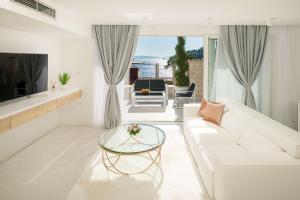 a living room with a white couch and a glass table at Beautiful Hvar Villa 4 Bedrooms Villa Hvar Majestic Resort Centre Location & Wonderful Sea Views in Hvar