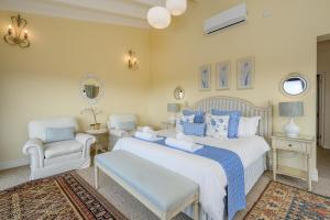 a bedroom with a large bed and two chairs at San Lameer Villa 14317 - 4 Bedroom Deluxe - 8 pax - San Lameer Rental Agency in Southbroom +46 photos