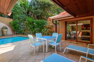 a patio with a table and chairs next to a pool at San Lameer Villa 14317 - 4 Bedroom Deluxe - 8 pax - San Lameer Rental Agency in Southbroom
