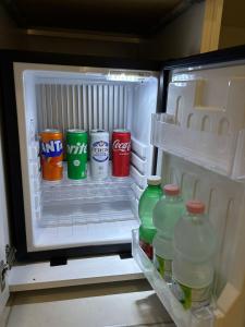 an open refrigerator filled with drinks and soda at Dallatorre B&B in Lizzano