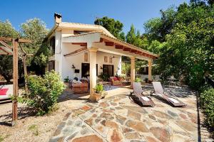 a house with a patio with two lounge chairs at Finca la Noguera-Sierra Cazorla in Quesada