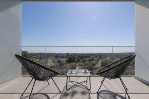 two chairs and a table on a balcony with a view at Elegant Studios in Katowice with Gym, Sauna & Cinema by Noclegi Renters in Katowice