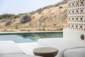 a white couch sitting next to a swimming pool at Cavo Marelia in Amoopi