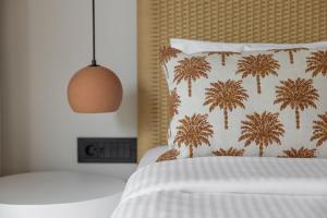 a bed with a pillow with palm trees on it at Cavo Marelia in Amoopi