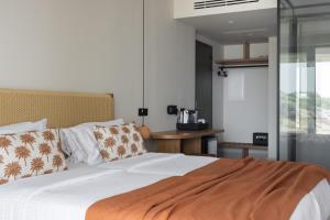 a bedroom with a bed with white sheets and pillows at Cavo Marelia in Amoopi