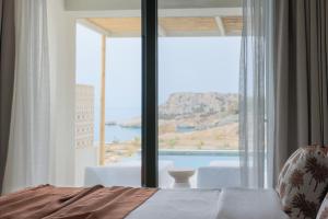 a bedroom with a large window with a view of the water at Cavo Marelia in Amoopi