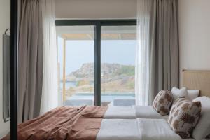 a bedroom with a bed and a large window at Cavo Marelia in Amoopi +37 photos
