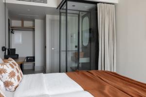 a bedroom with a bed and a glass shower at Cavo Marelia in Amoopi