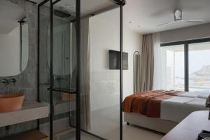 a bedroom with a bed and a glass shower at Cavo Marelia in Amoopi
