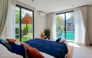 une chambre avec un lit et une vue sur une piscine dans l'établissement Bougainvillea Luxury Pool Villas, à Ban Pak Lak