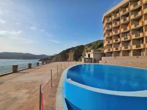 a hotel with a swimming pool next to the water at Appartamento Blu Mare in Teulada