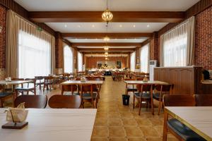 UrhoKaramay West Wuzhen Tancheng Hotel的有桌椅和窗户的餐厅