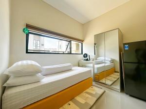 a small bedroom with two beds and a mirror at Rumah Mungil Nyaman in Muara +56 photos