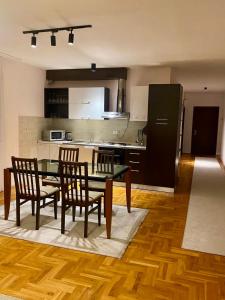 cocina con mesa y sillas y cocina con nevera en Apartment X, en Pristina